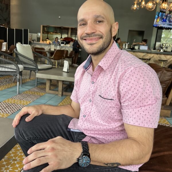 Close up of a man wearing a pink shirt