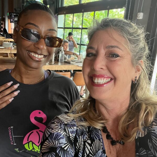 Two women, one wearing glasses, and smiling