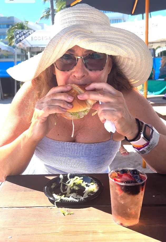 Woman wearing a hat eating a burger